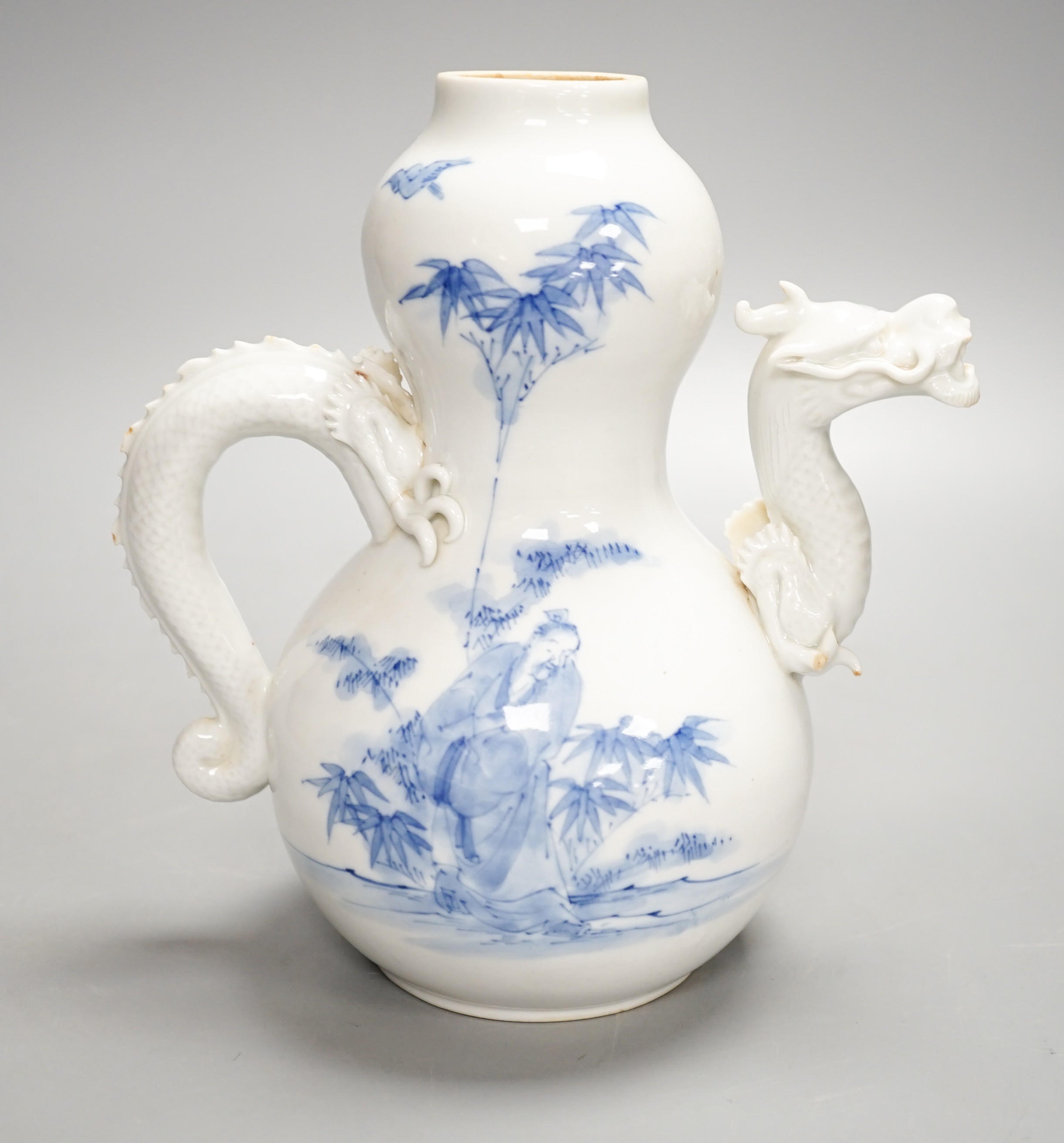 A Japanese Hirado blue and white 'dragon' wine pot, late 19th century, of double gourd shape, (losses) 19.5cm